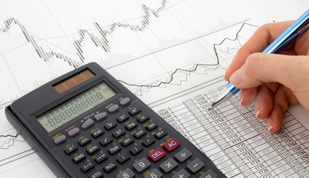 Calculator and person writing on chart