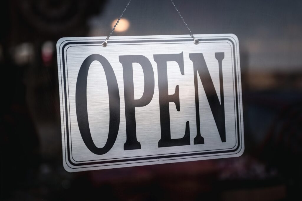 Open sign hanging in storefront window